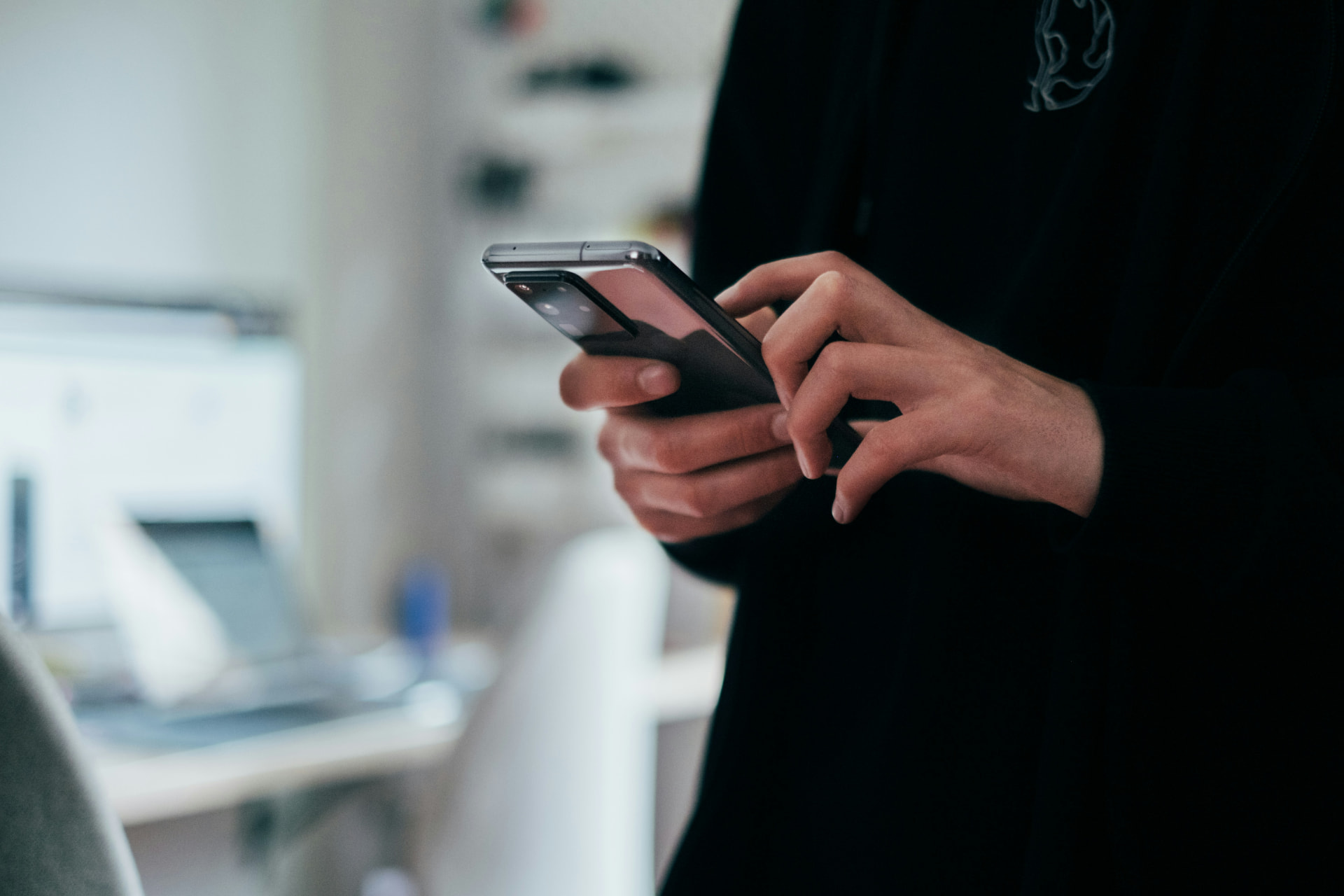 A technician helping a customer with a phone and tablet at the counter